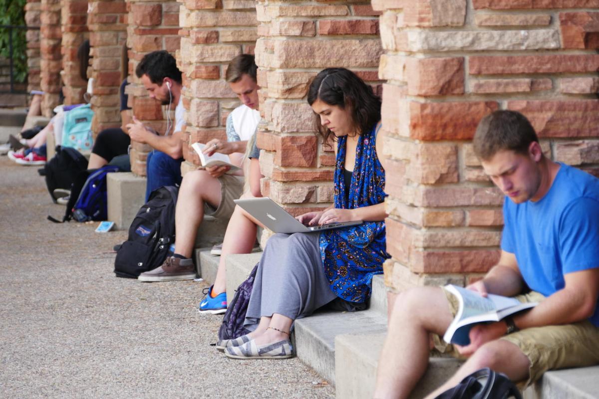 Students on laptops and studying outside of UMC building