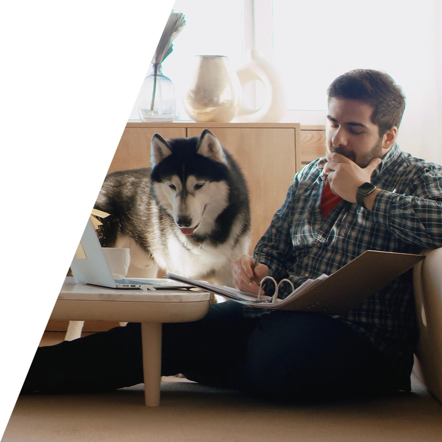 Man studying at home with his dog
