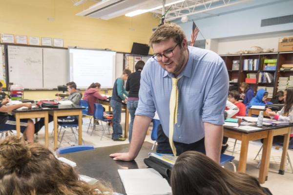 Male teacher in a classroom working with students