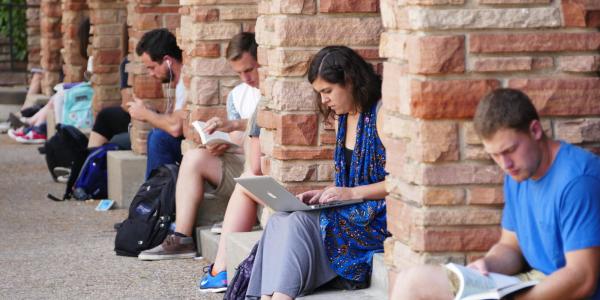 Students on laptops and studying outside of UMC building