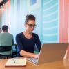 Student Jill Kollar working on at laptop in a coffee shop